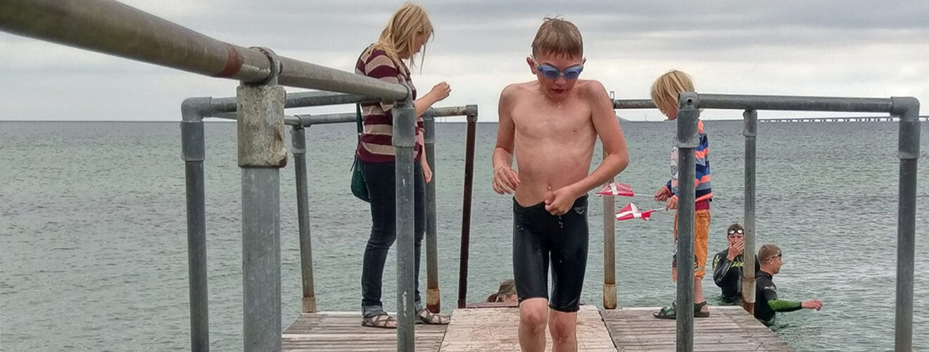 Svømmer i løb på vej op ad badebro