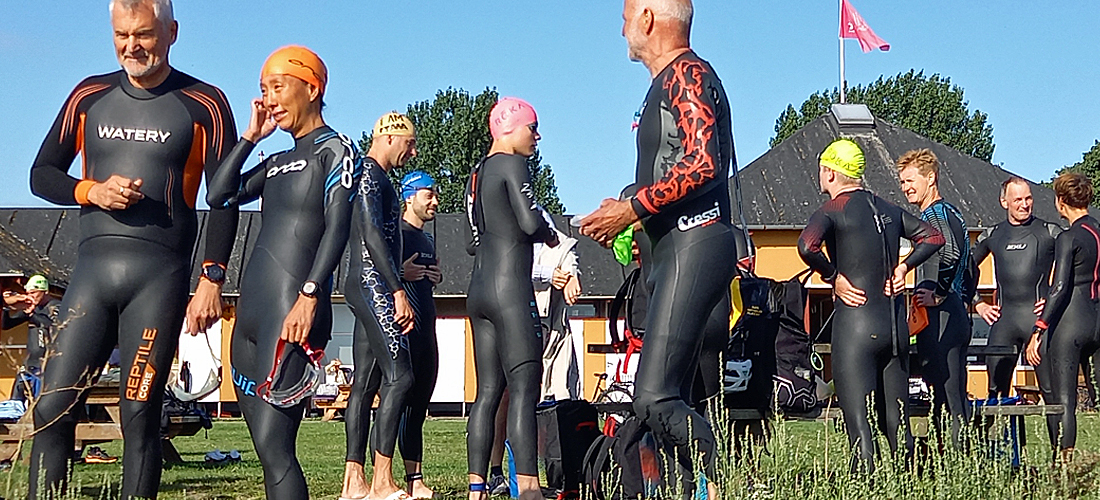 Fællesskab på stranden i våddragt inden race